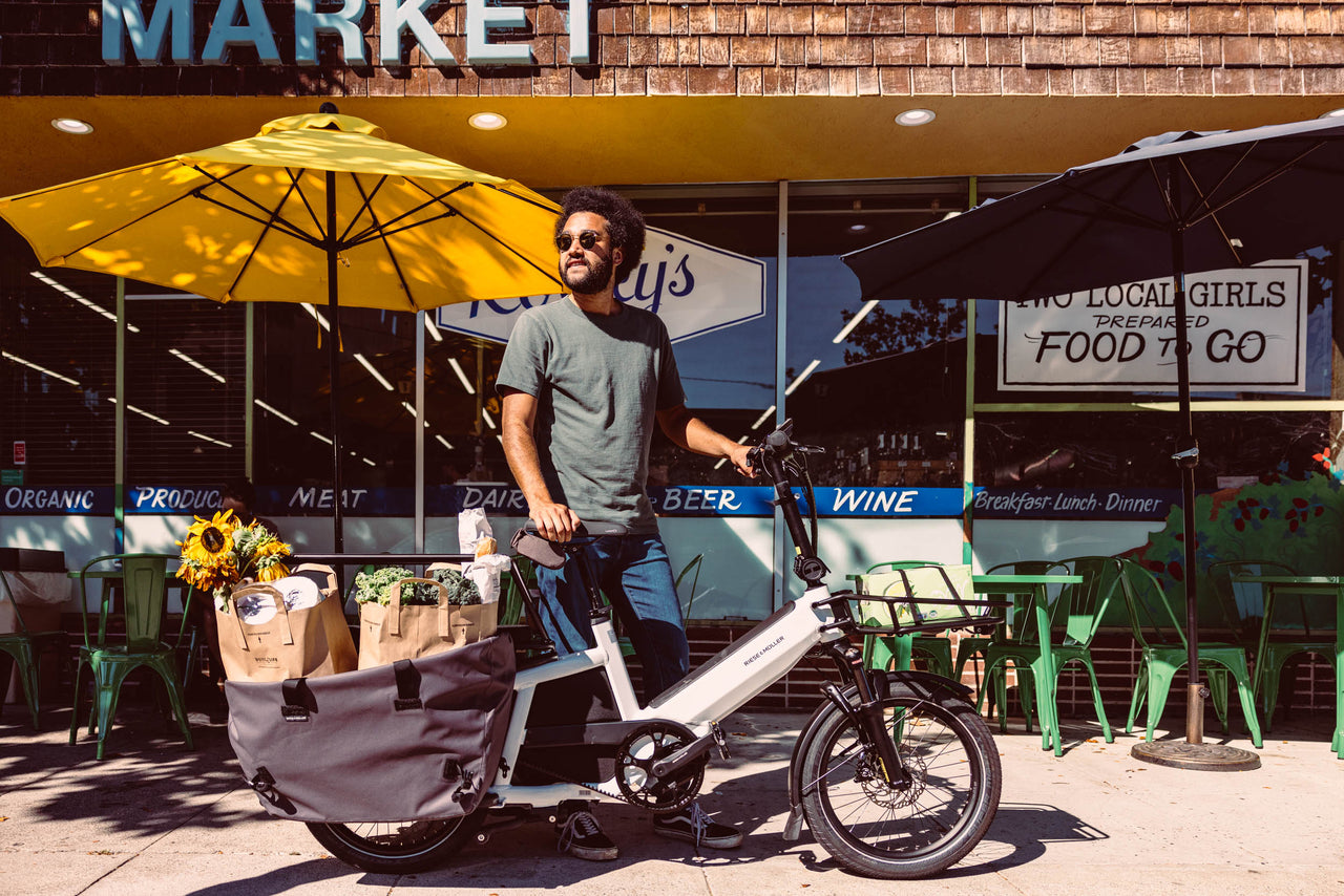 A person picking up groceries with their electric cargo bike
