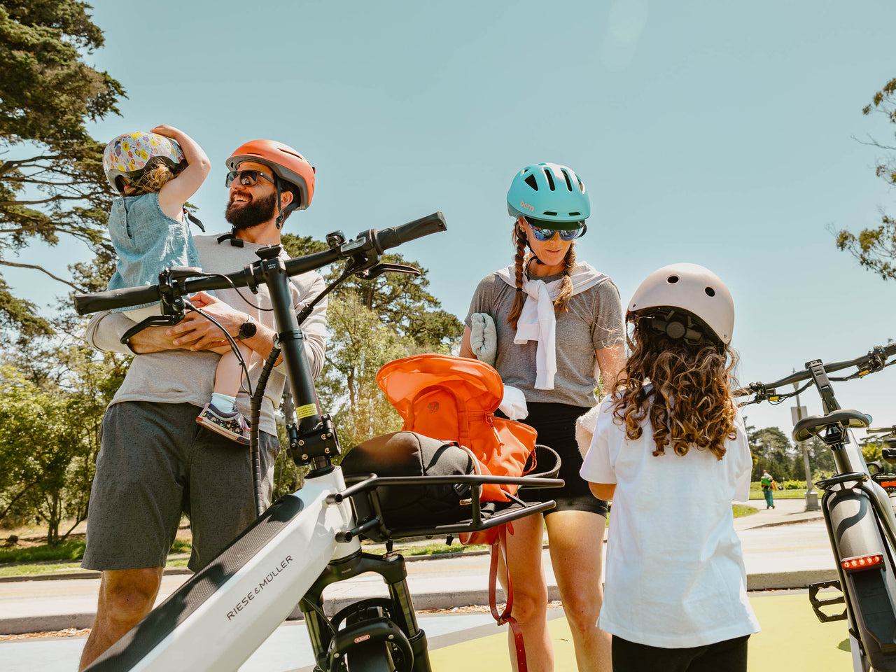 Family enjoying a park day on their electric cargo bikes